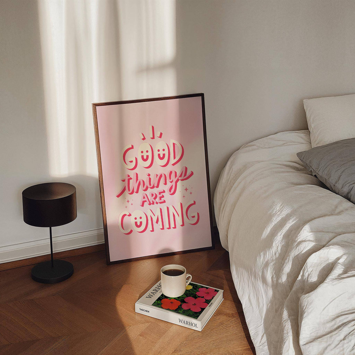 Motivational posters for students leaning on a wooden floor with pink typography and a black lamp nearby