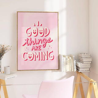 Motivational posters for students print with pink typography on a wall above a desk with books and a glass