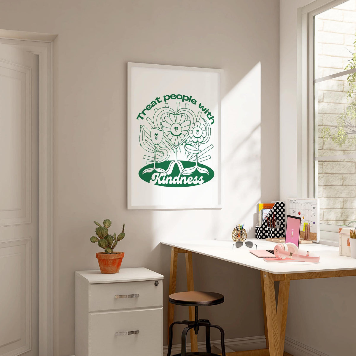 Positive Poster featuring smiling flowers with heart and green minimalist design in a sunlit home office above a small cactus