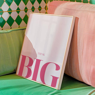 Framed print of think big typography in pink leaning on cushions with green and pink colours