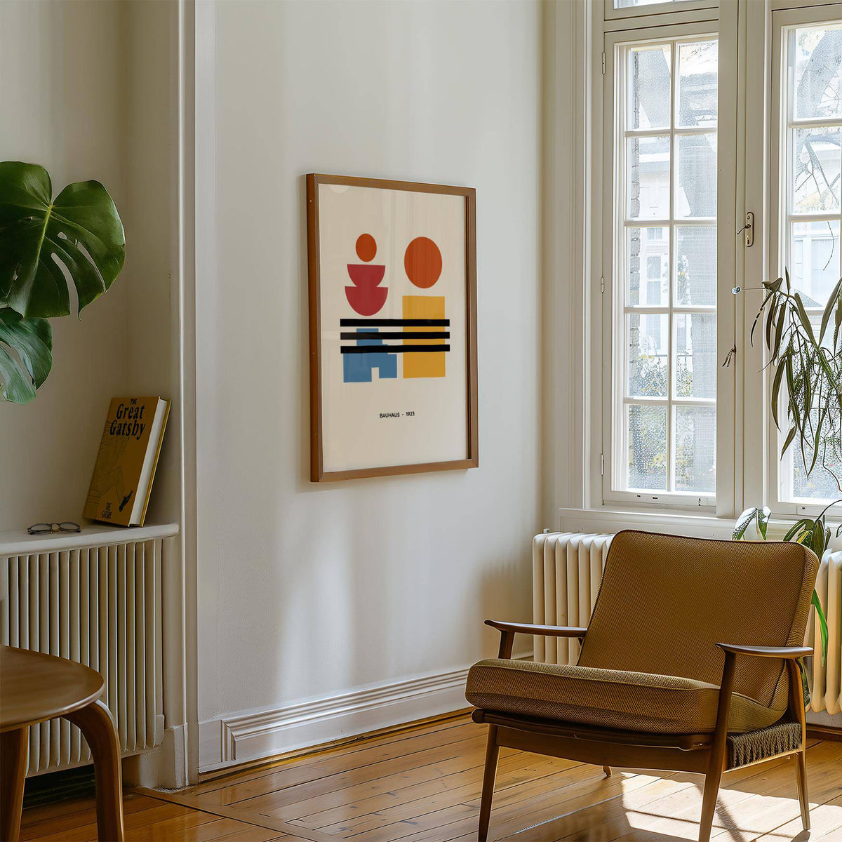 Minamalist Art framed print of geometric shapes in red blue yellow in a bright living room next to a brown armchair