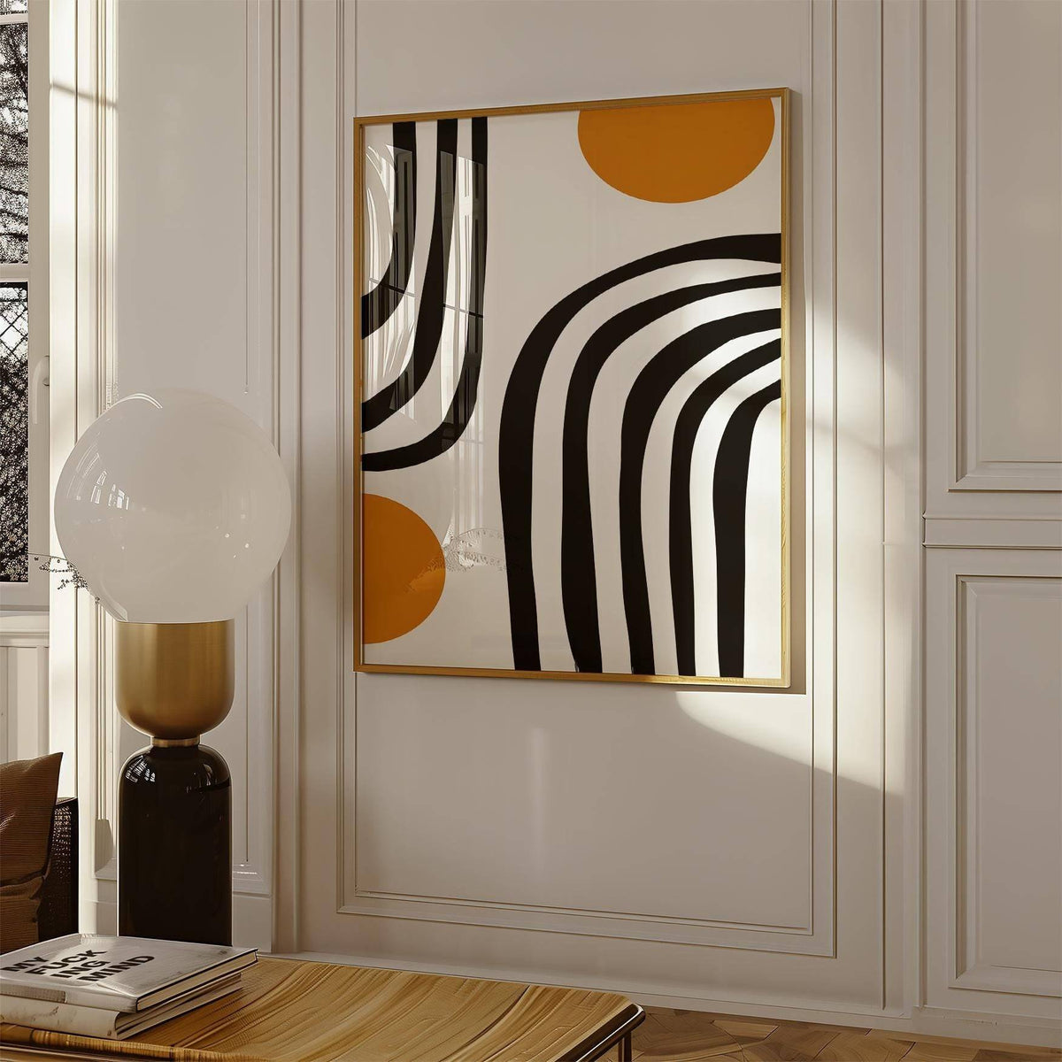 Orange and Black wall art with black curved arcs and ochre circles in a room with a lamp on a wooden table