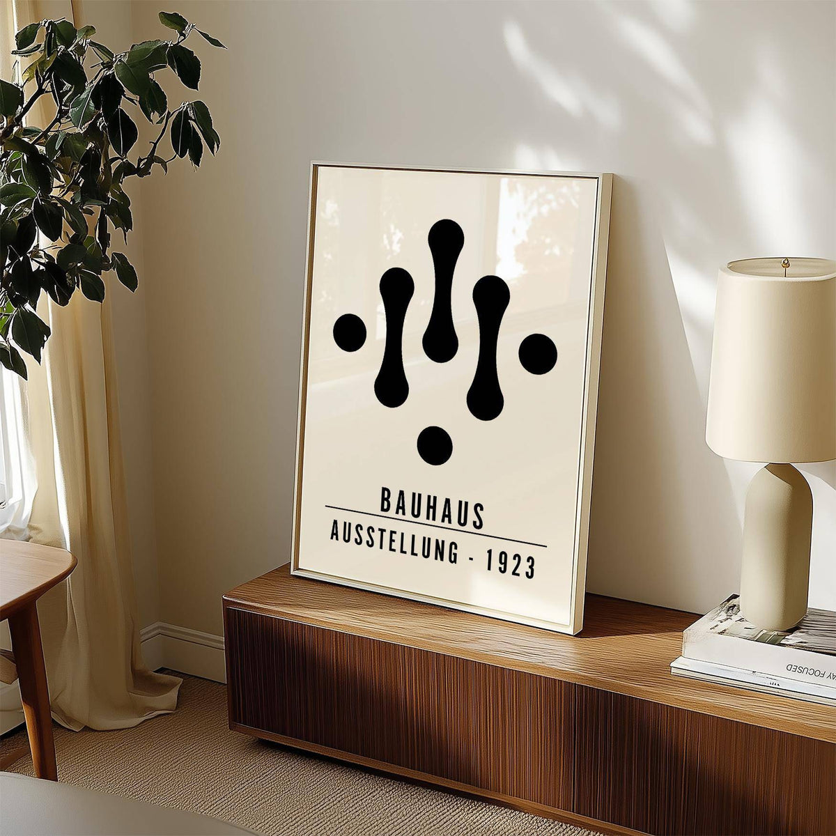Print leaning on a wooden sideboard with Bauhaus Art Black and White abstract shapes near a lamp