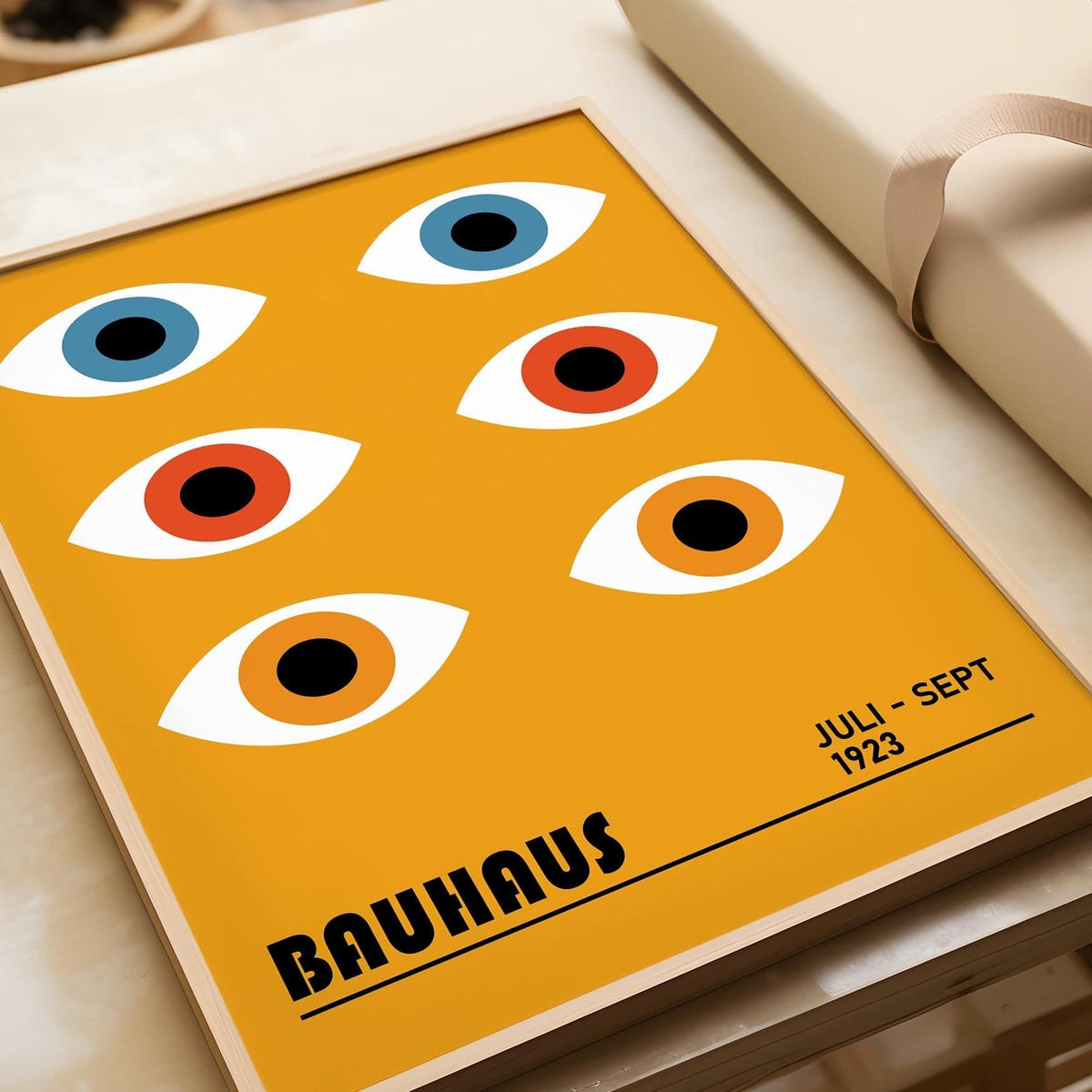 Eye Poster with stylised blue orange eyes and bauhaus text on a yellow background