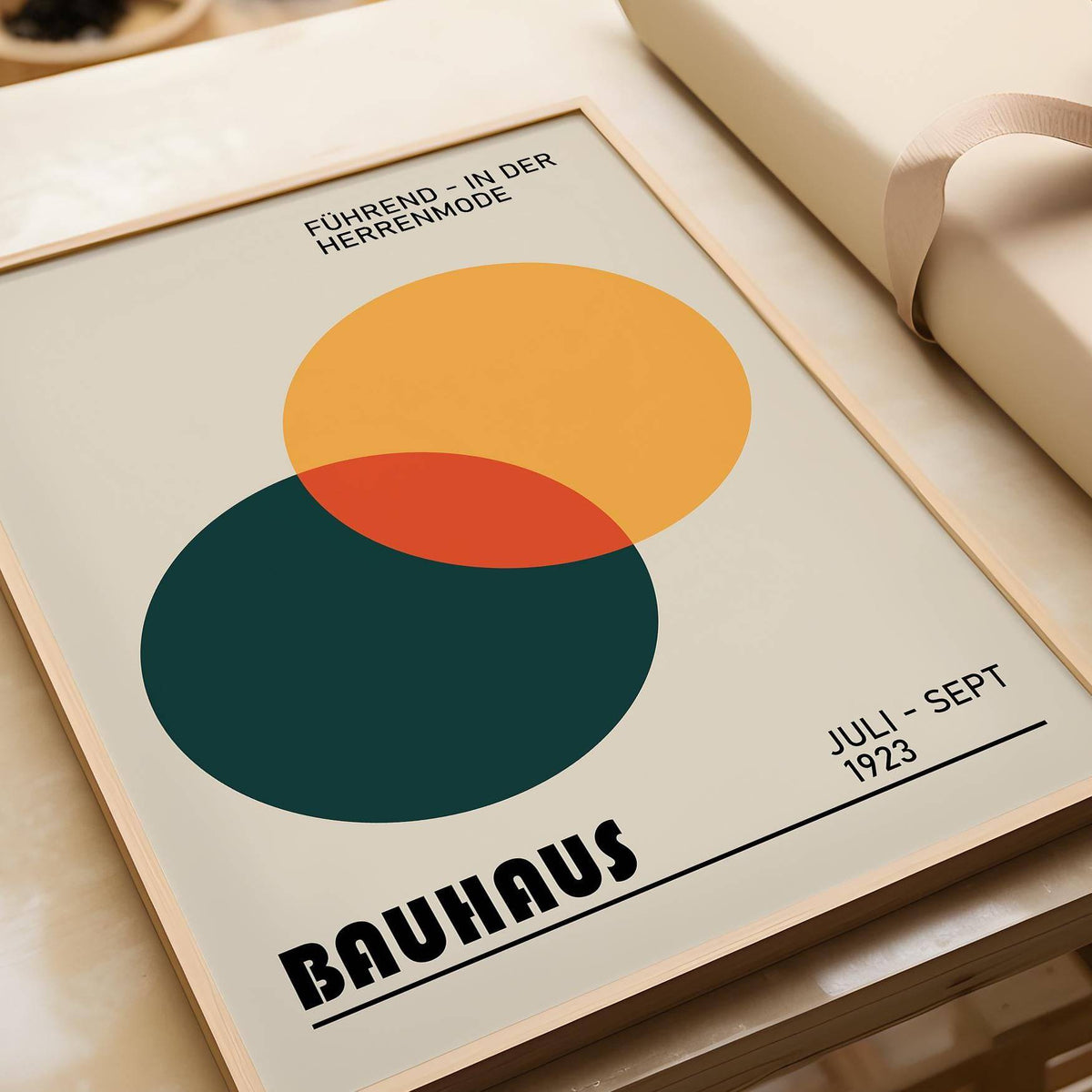 Print Geometric framed print close-up showing overlapping circles in orange and dark green on a beige background with a wooden frame