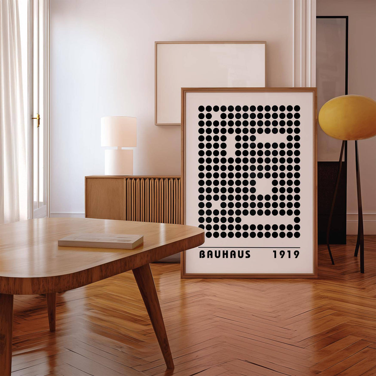 Bauhaus Prints leaning print with black dot pattern and oak frame beside a yellow lamp in a room
