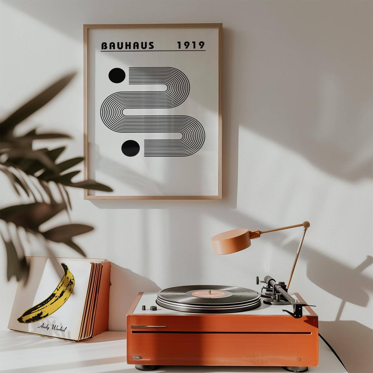 Black and White Minimalist Art framed print with linear design above a red record player with a lamp