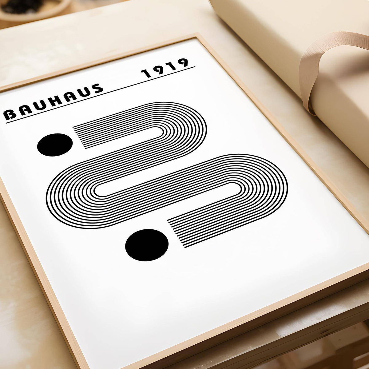 Black and White Minimalist Art close-up with abstract linear shapes and two circles on a beige table near wrapping paper