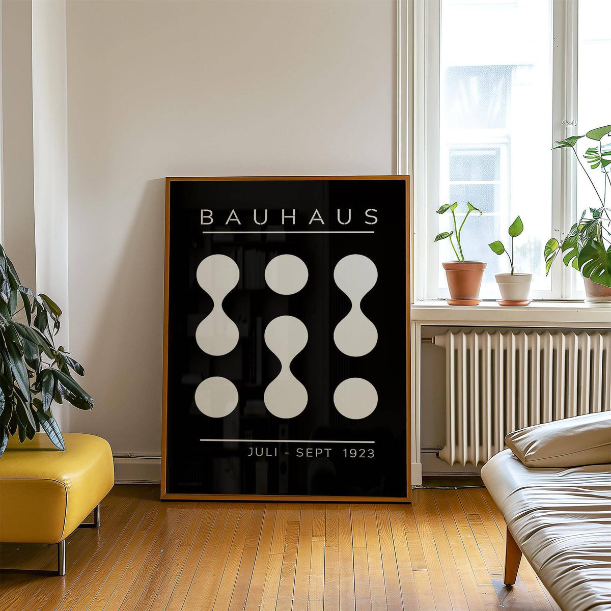 Black and White Geometric Art print leaning on a wooden floor with plants nearby in a bright room