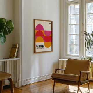 Large Artwork for Walls with geometric semi-circles in pink, red and orange on a white wall above a brown armchair