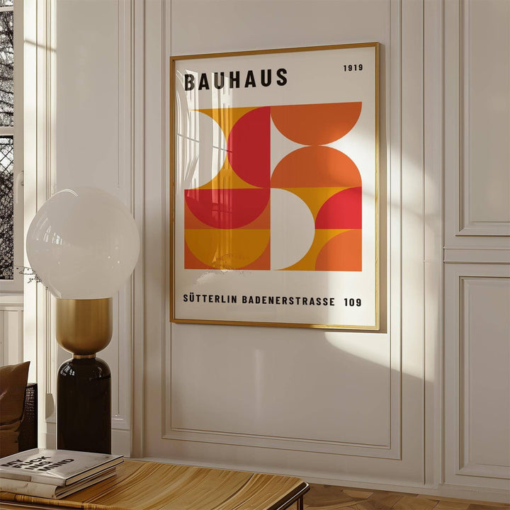 Mid Century wall art with geometric shapes in red orange and white in a living room with a modern lamp