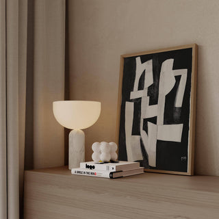 Print leaning on a shelf of white abstract shapes on a black background with a white lamp