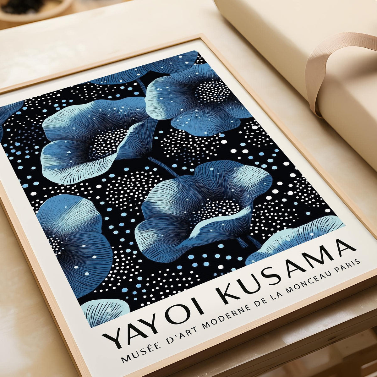 Framed close-up of wall art blue flowers with dark background and white text on beige surface
