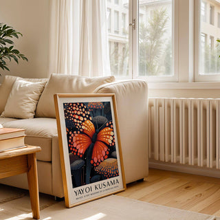 Poster Butterfly framed print with an orange butterfly on a sofa beside books and a plant