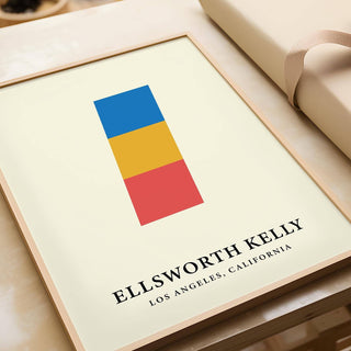 Framed Creative Wall Art of stacked blue yellow and red blocks lying on a table next to wrapping paper