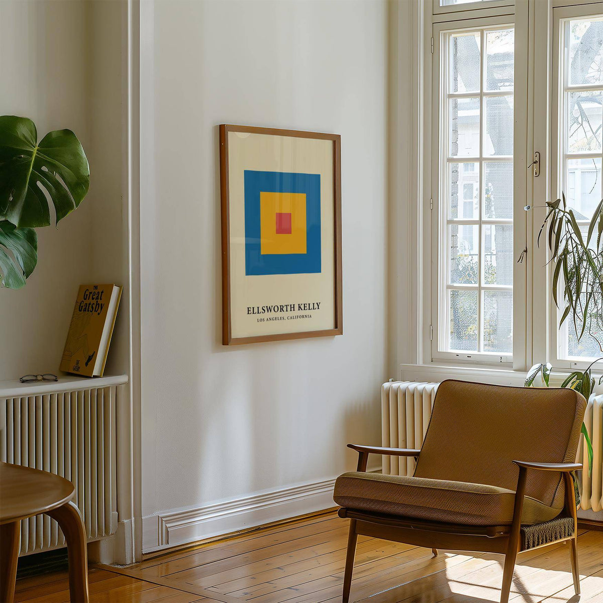 Minimalist art framed print with concentric blue, yellow and red blocks in a bright sitting room with a brown armchair