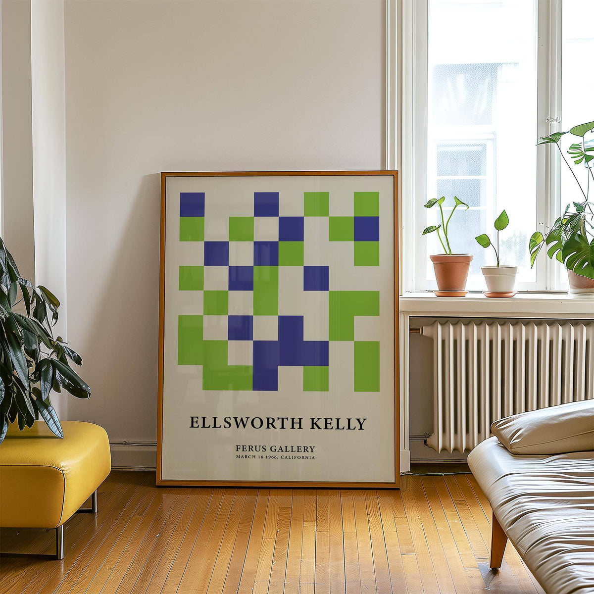 Minimal wall art with green and blue squares leaning on a wooden floor near a yellow chair and a window with plants