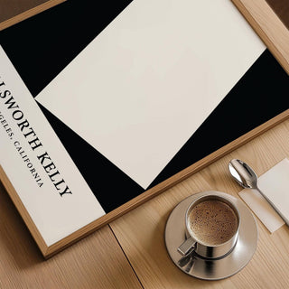 Framed close-up of black and white office print with cup of coffee on wooden surface