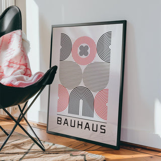 Wall Art for Home Office leaning framed print of abstract geometric shapes in black and red beside a black chair with a patterned throw