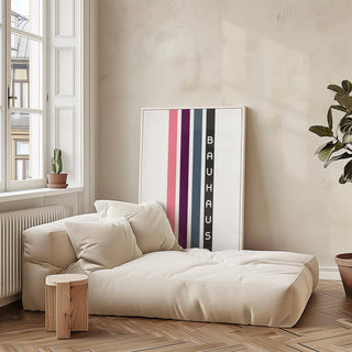 Geometric Art Wall print with vertical stripes in pink, purple and grey leaning above a beige sofa with cushions