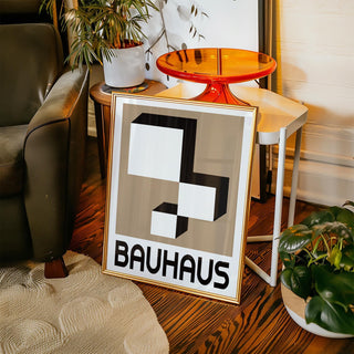 Geometric wall hanging leaning on a side table with plants and an orange glass tray
