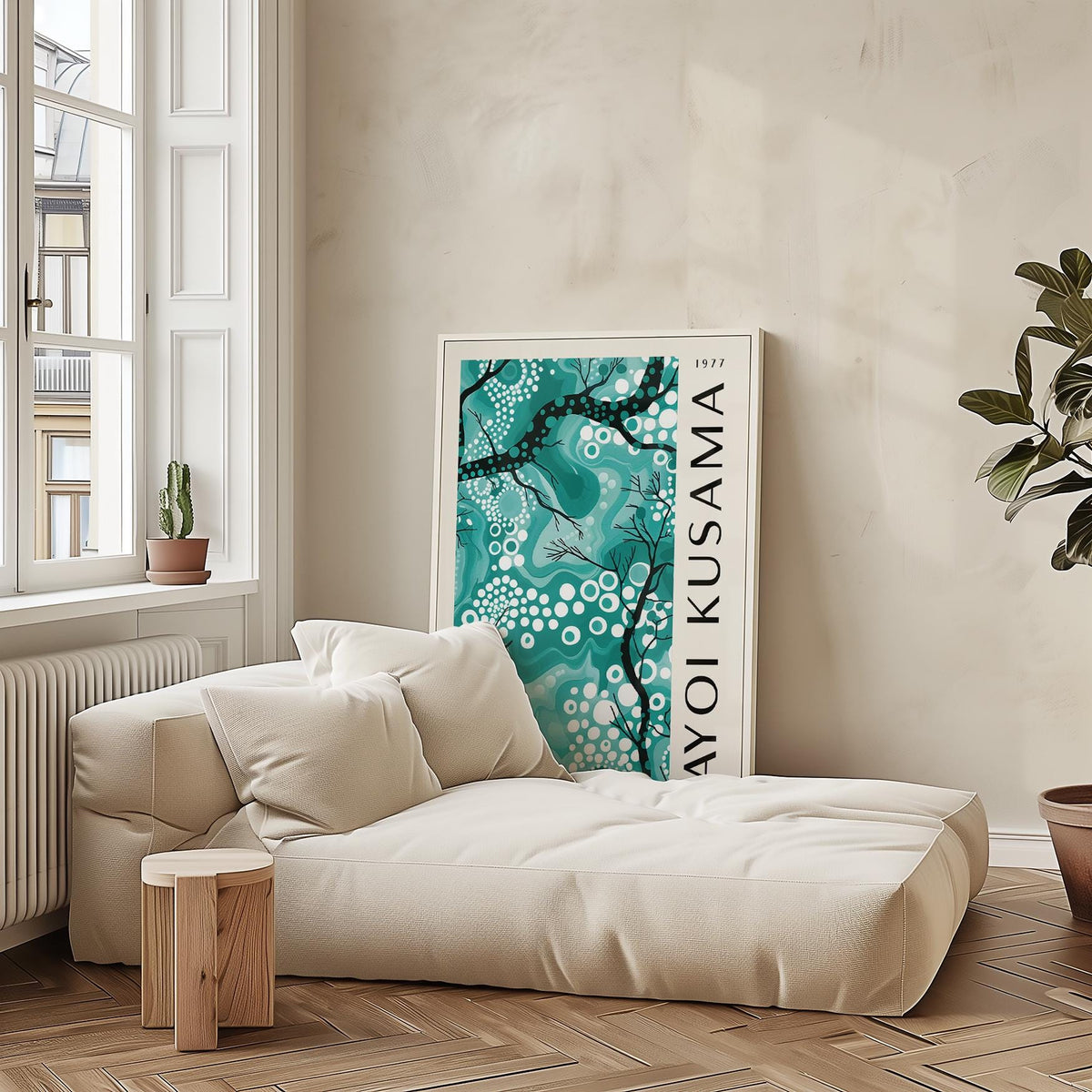 Teal wall decor leaning on the floor with white and black abstract branches beside a cream sofa and plant