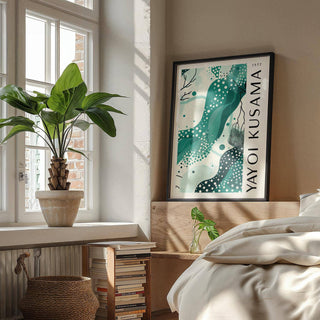 Black White and Green Poster leaning on a wooden headboard abstract aqua shapes and polka dots in a bedroom with plants