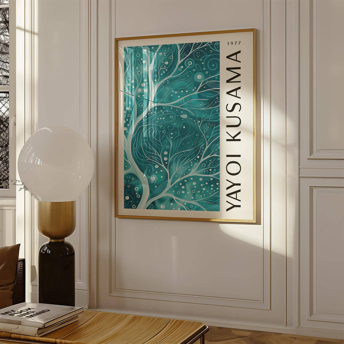 Teal colour wall art of abstract branches in a gold frame hanging above a table with a lamp