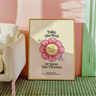 Motivational Quotes wall art with smiling pink flower leaning against a pink wall near an armchair