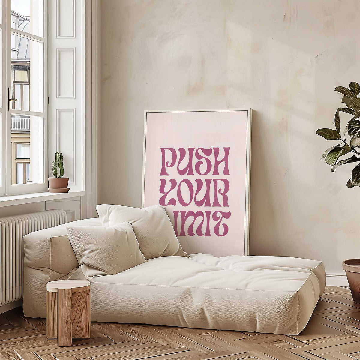Quote Motivational Posters leaning print with pink text on pale background beside a beige sofa and small wooden stool