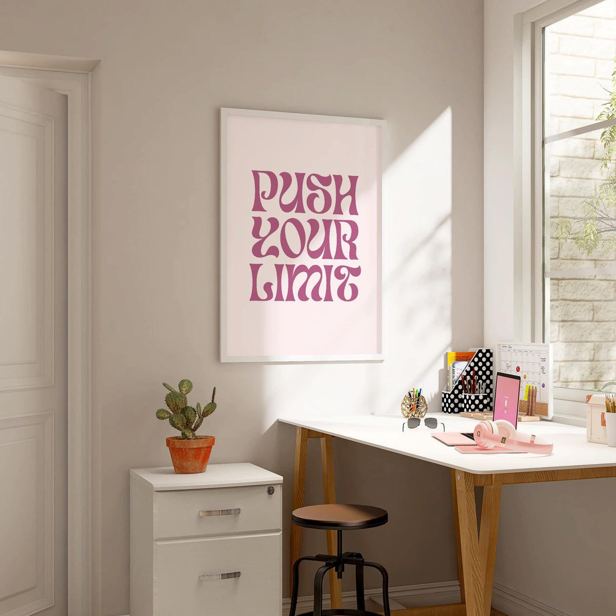 Quote motivational posters with pink text on a white background in a bright office with a potted cactus