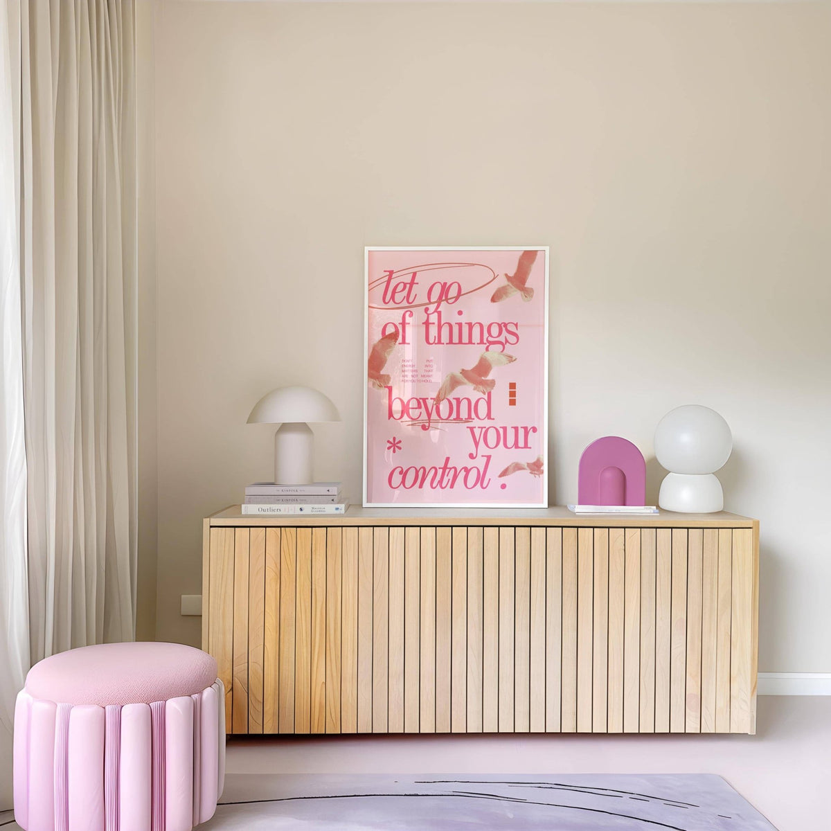 Posters with Inspirational Sayings print with pink and red typography above a wooden sideboard with lamps