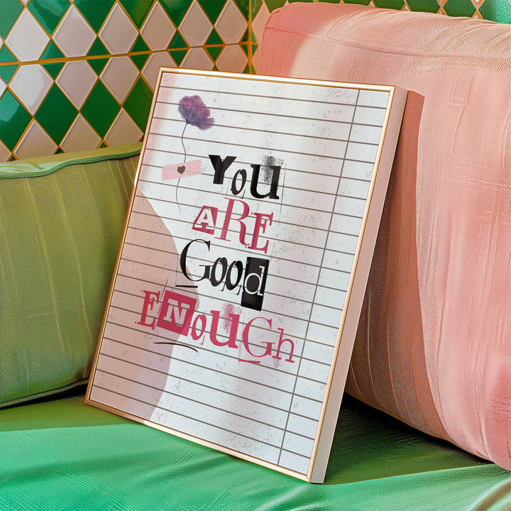 Framed print of typographic You Are Good Enough motivational quote with a purple flower leaning on a green and pink cushion