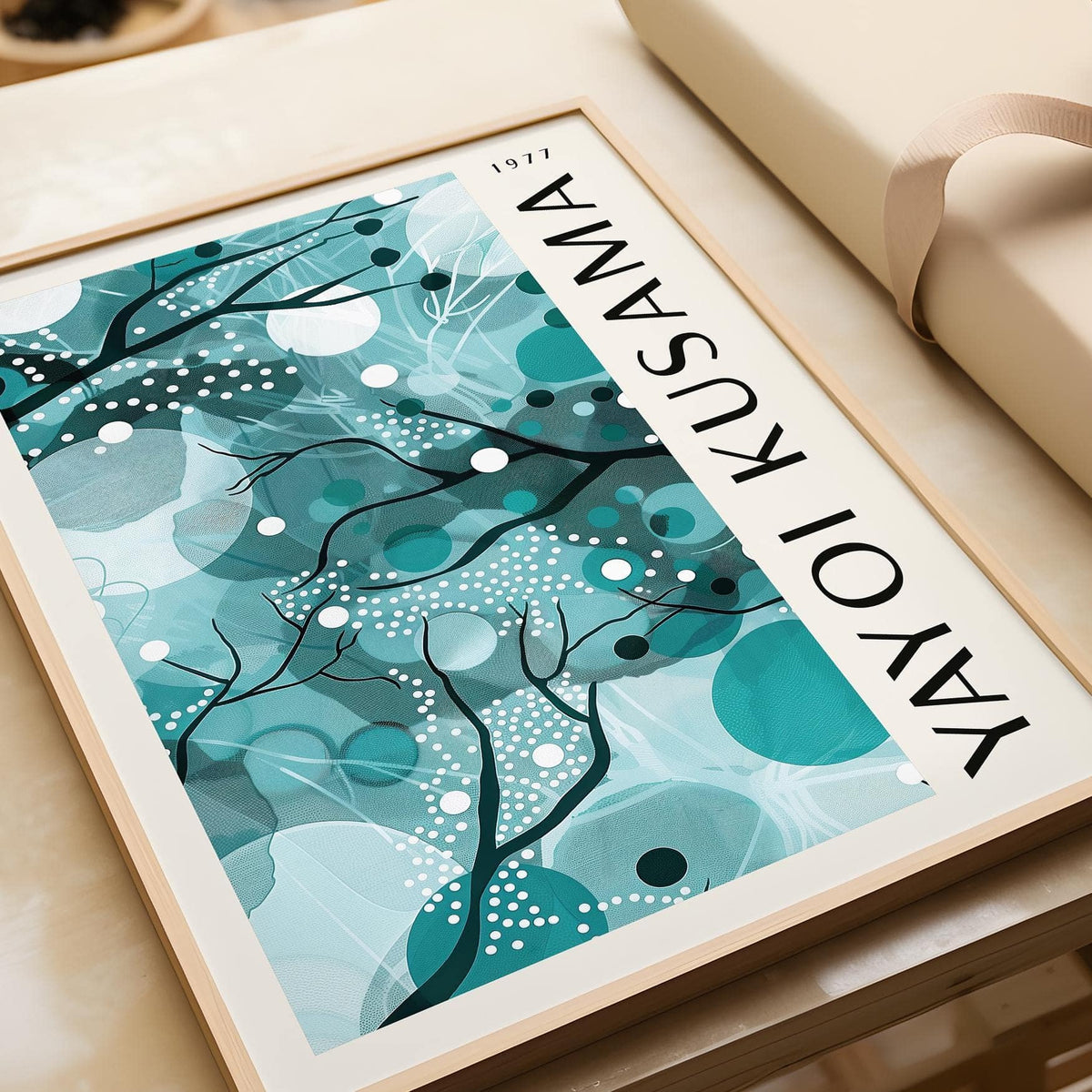 Framed print close-up showing Wall Art with Teal Colors abstract organic shapes and black lines on a beige surface with gift wrap nearby