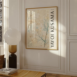 Nature prints framed print with abstract tree branches and circles in soft beige and blue next to a lamp on a carved white wall