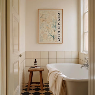 Nature Prints hanging above a wooden stool by a bathtub in a tiled bathroom