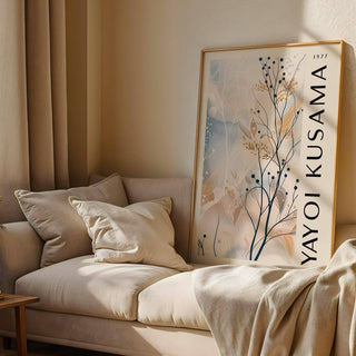 Large Neutral Wall Art leaning on sofa with neutral cushions and a plant nearby in a softly lit room