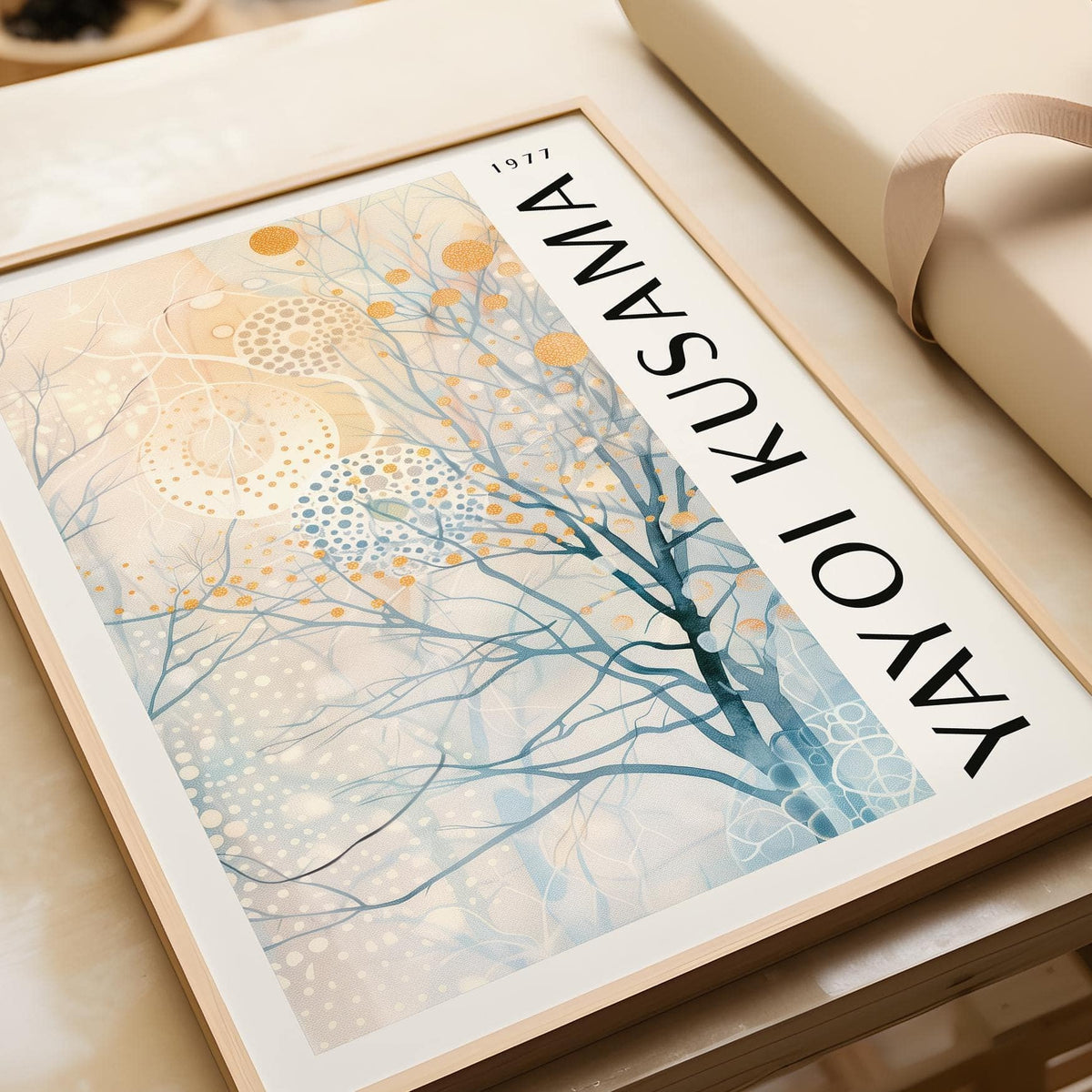 Close-up of sitting room art with abstract tree and orange and blue dots in a light wooden frame