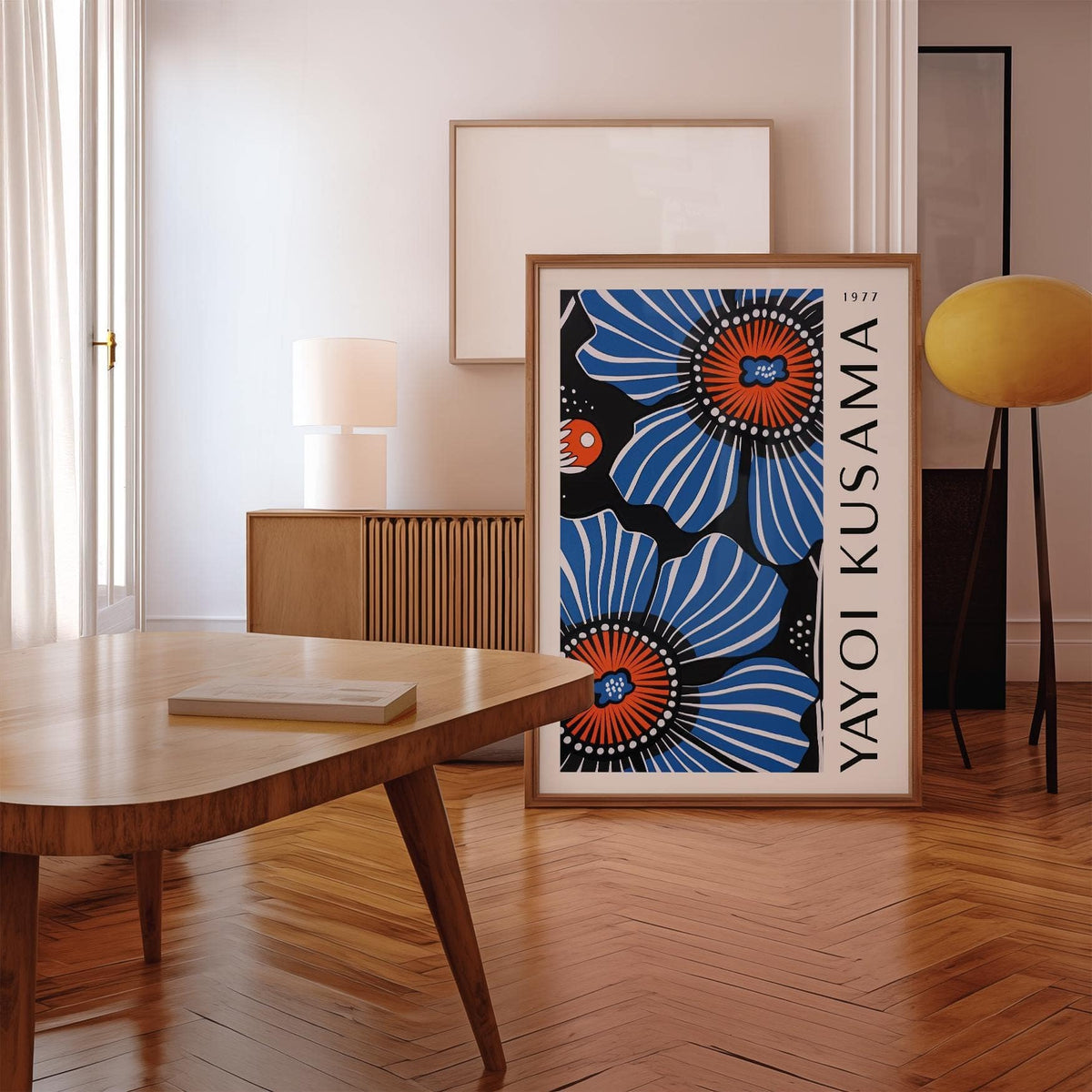 Print leaning on the floor showing blue poppy flowers in minimalist style with a lamp in the background