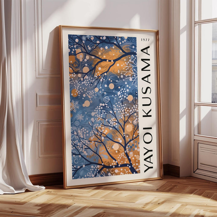 Blue wall art for living room leaning against wall showing abstract tree branches with blue and orange hues