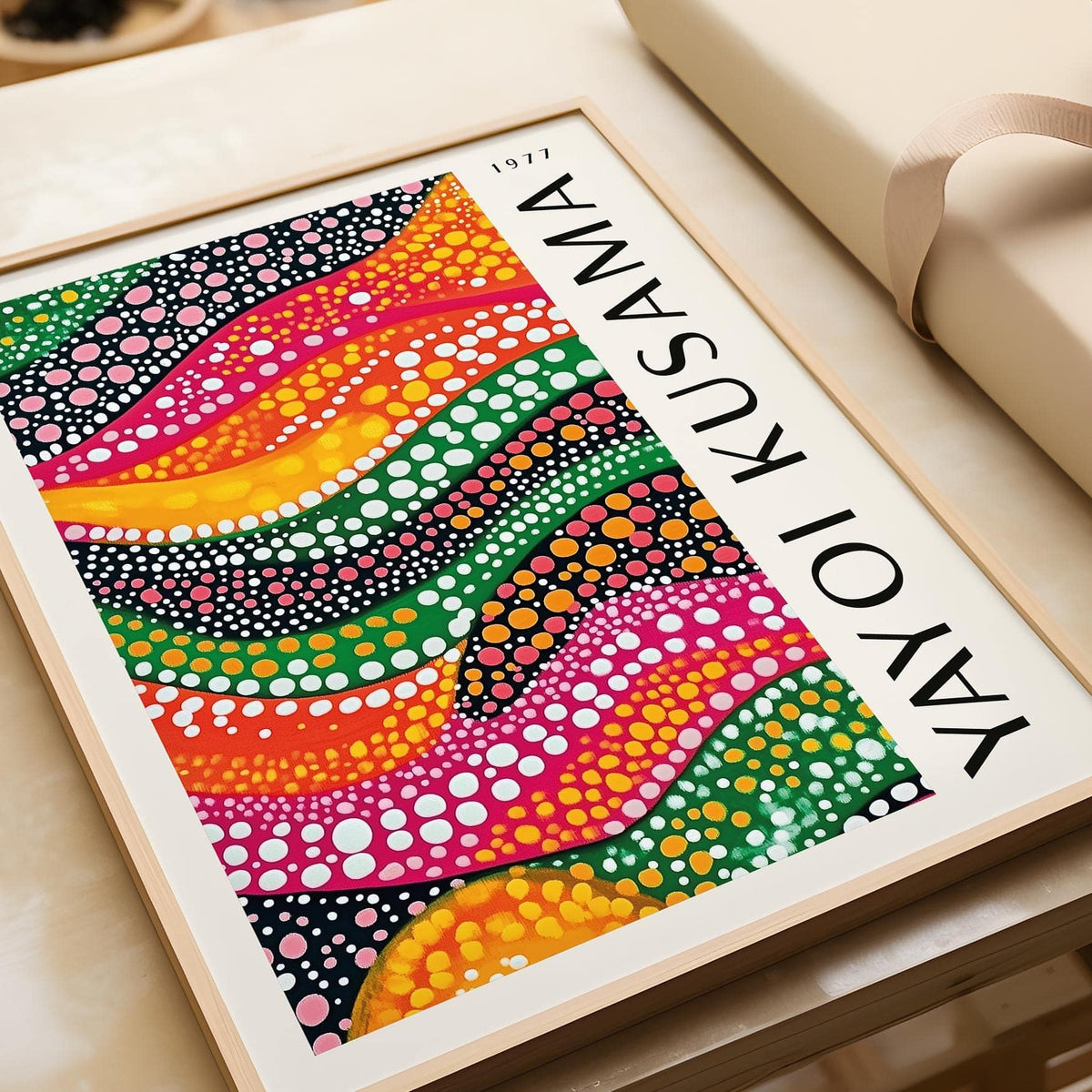 Framed Polka Dot Art print with dotted colourful waves leaning on a beige sofa