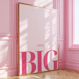 Print leaning on floor with think big typography in pink beside a pink panelled wall