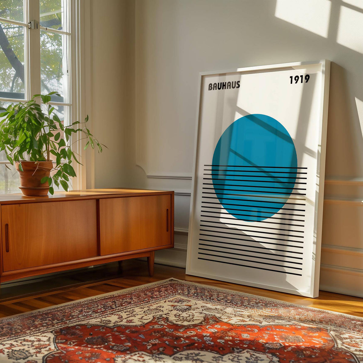 Minimlist Art print leaning on the floor with blue circle and black lines near a wooden cabinet and plant