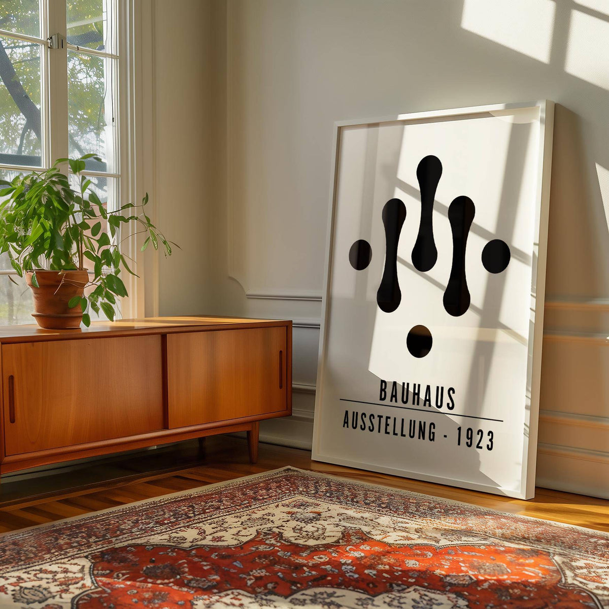 Print leaning on floor with Bauhaus Art Black and White abstract shapes and text near a wooden sideboard