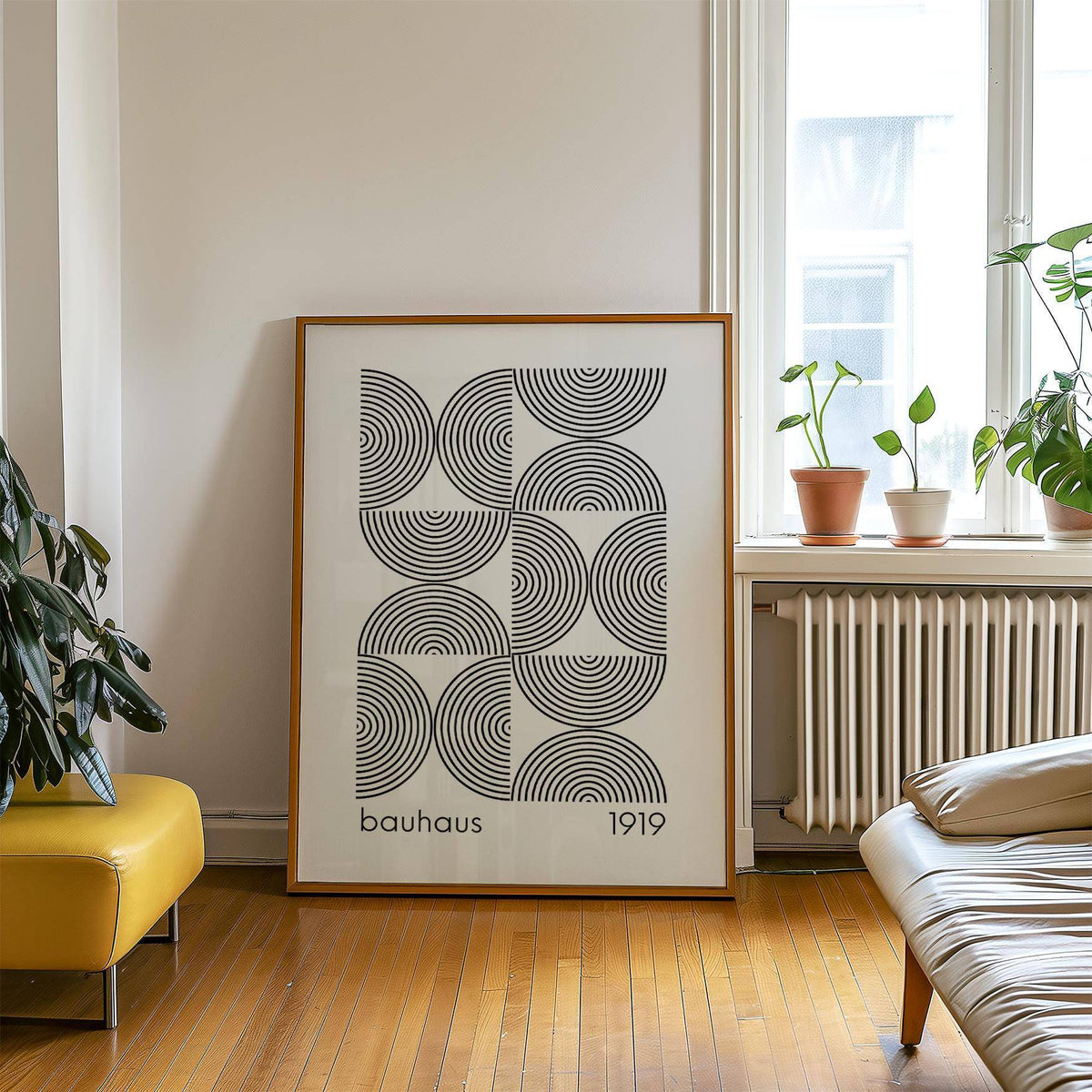 Print leaning on a floor showing black concentric semicircles in bauhaus style next to green plants