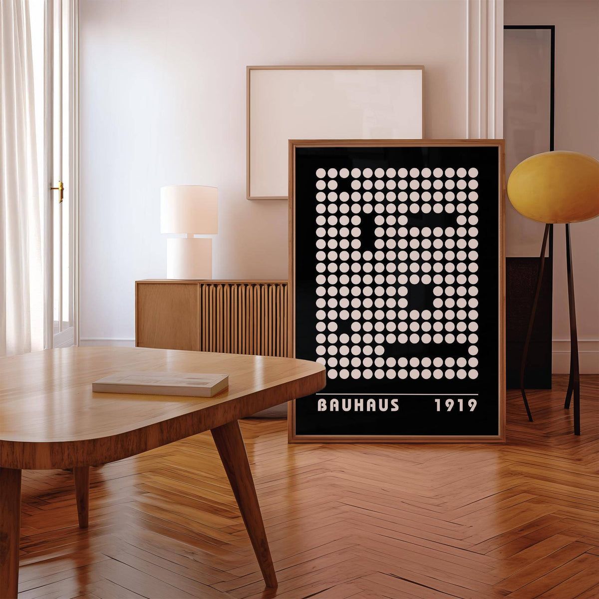 Digital wall art of an abstract dot pattern in black and white leaning against a sideboard with a lamp in a room
