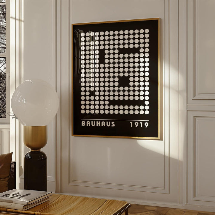 Framed digital wall art with a white dot pattern on black and bauhaus text near a lamp