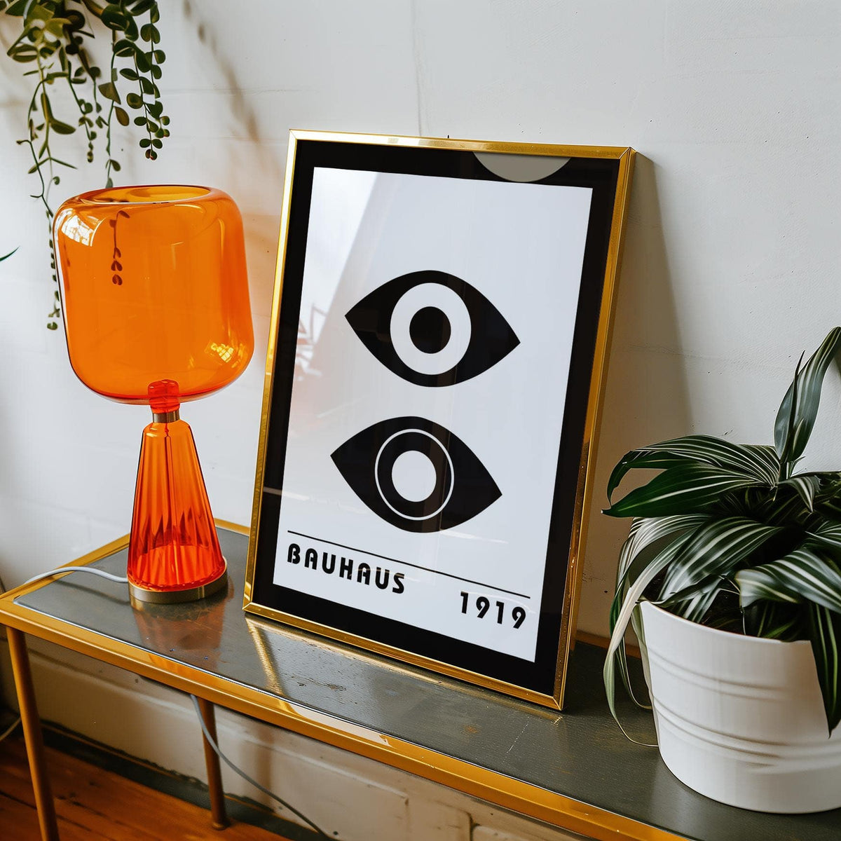 Framed Bauhaus Art Print of stylized eyes in black and white leaning on a metal table with orange lamp