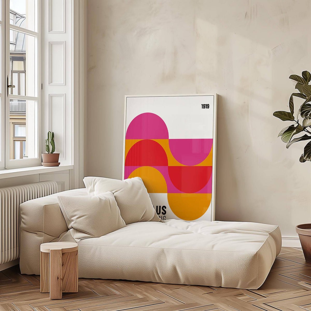 Large Artwork for Walls leaning on a neutral wall with semi-circles in pink red and orange beside a cream sofa with cushions