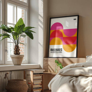 Large artwork for walls with semi-circles in pink red and orange leaning on a wooden headboard in a bedroom
